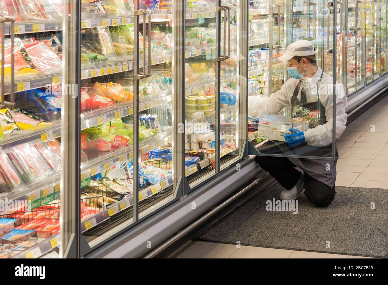 Campobasso,Molise Region,Italy:An employee supplies the refrigerator shelf inside a supermarket with products during the coronavirus emergency in Ital Stock Photo