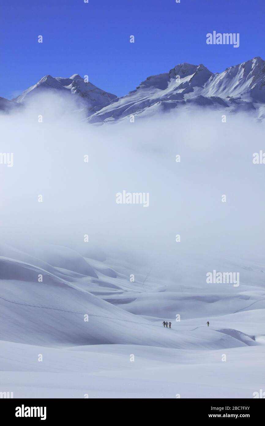 Bivio, Skitour Roccabella. Aufstieg unter Nebelbank.Blick auf Piz Duan, Piz Mäder und Piz Turba. Stock Photo