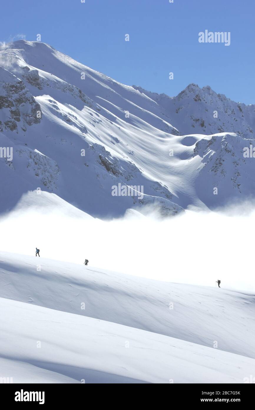 Bivio, Skitour Roccabella. Aufstieg über Nebelbank. Blick gegen Piz Grevasalvas. Stock Photo