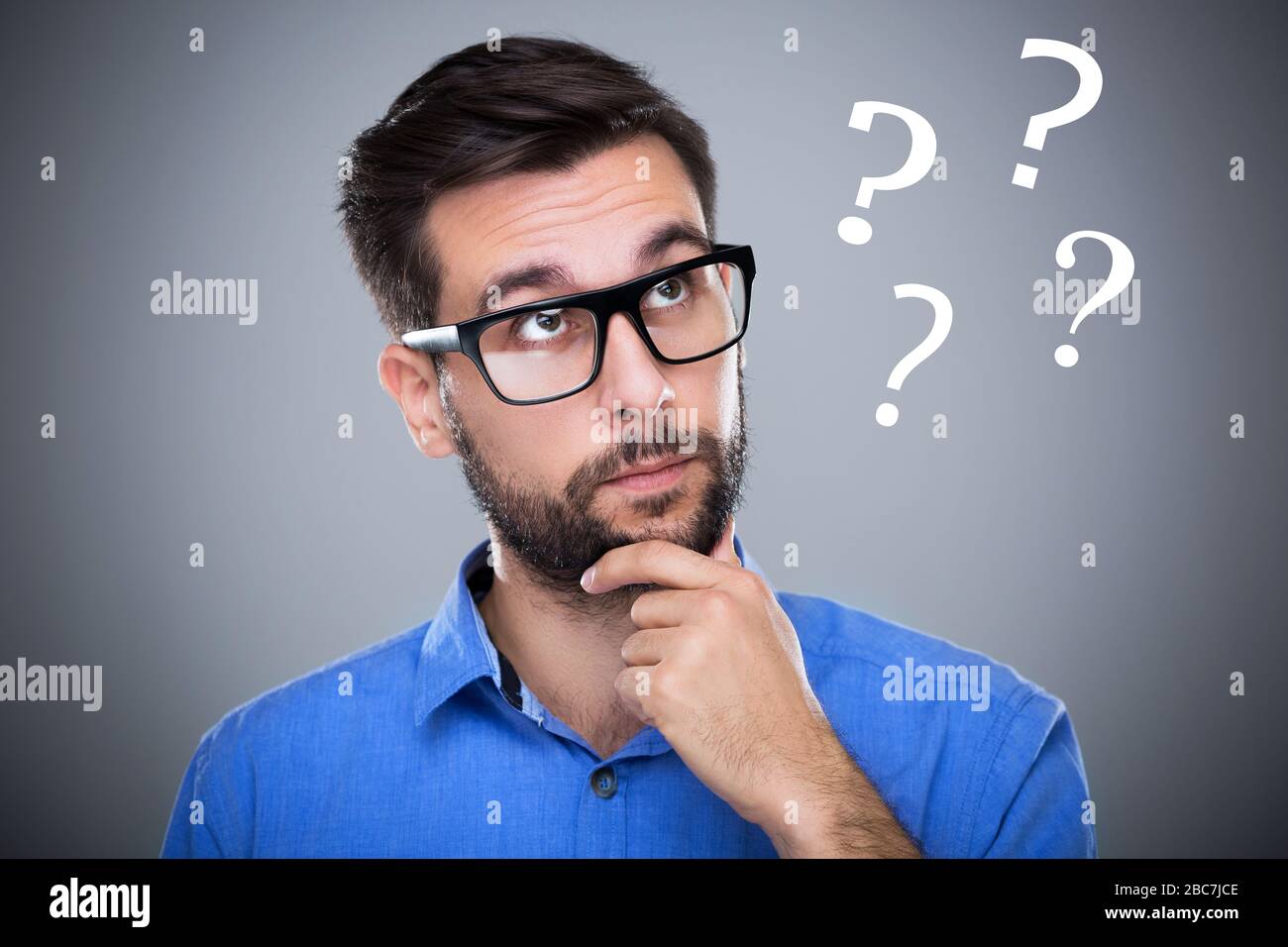 Man thinking with question marks Stock Photo
