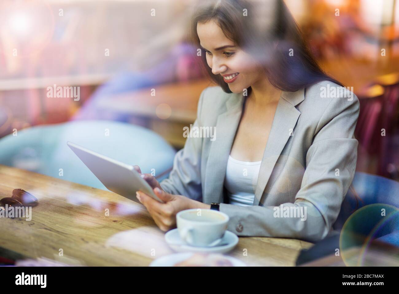 Young woman seen through cafe window Stock Photo