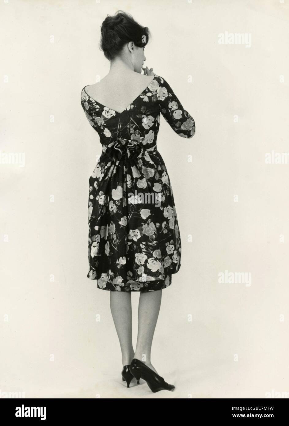 Model from the 1960s presenting an outfit with floral dress, Italy Stock Photo