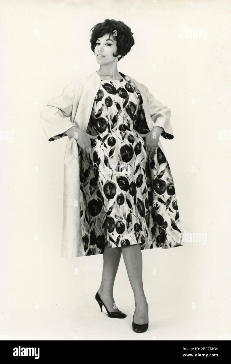 Model from the 1960s presenting an outfit with floral dress and matching coat, Italy Stock Photo