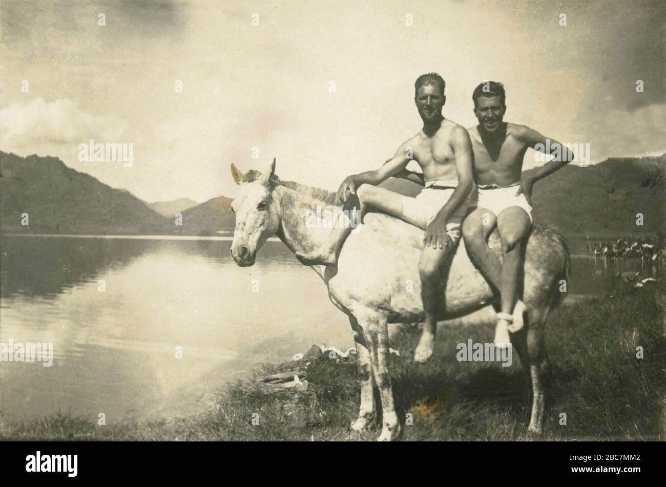 Two men on a white horse at the lake, Italy 1930s Stock Photo