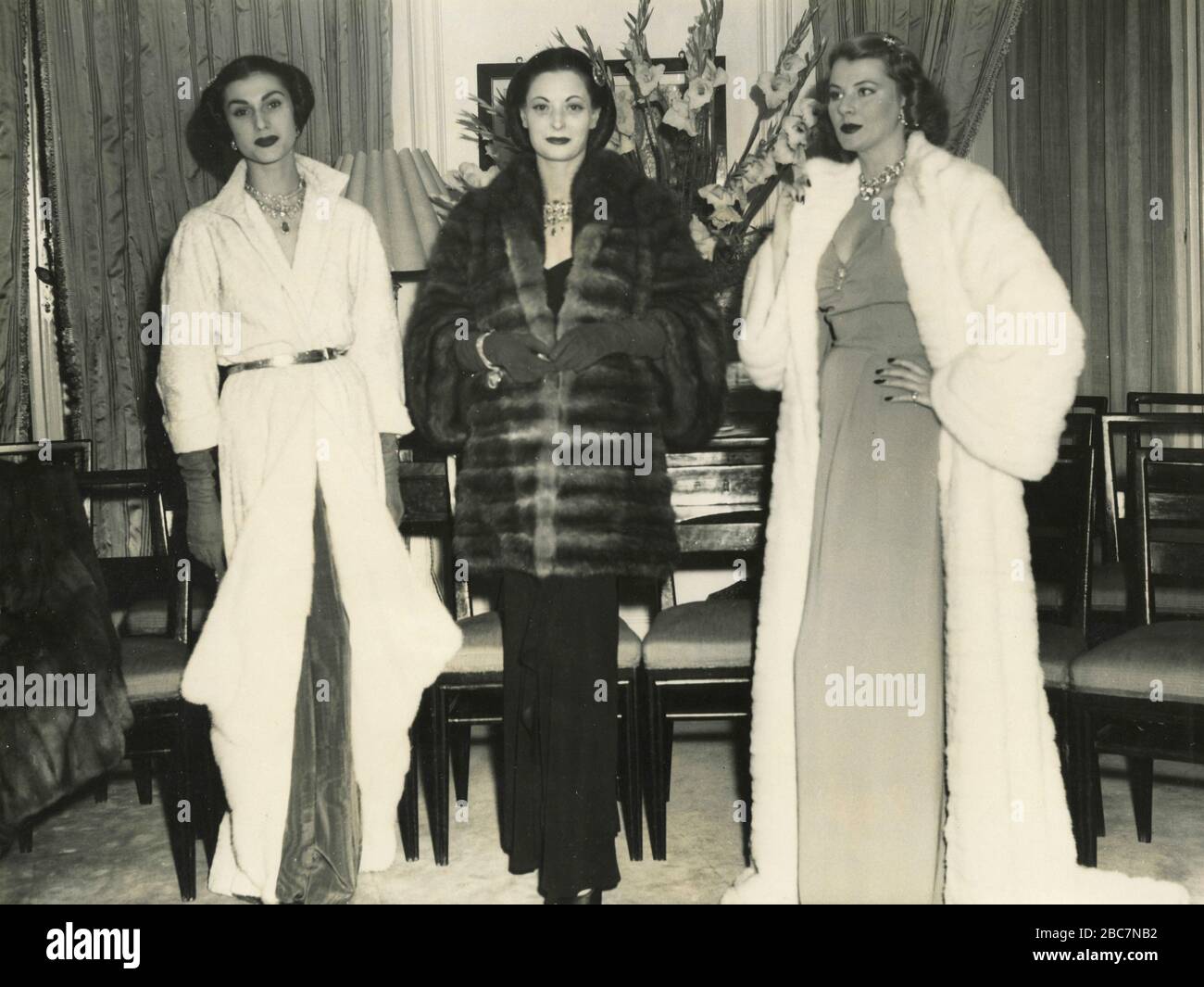 Models showing Lorini collection Paradiso delle Signore: A breitschwanz white mantle garnished with white mink, a Russian imperial sable jacket, and white mink mantle, Rome, Italy 1950s Stock Photo