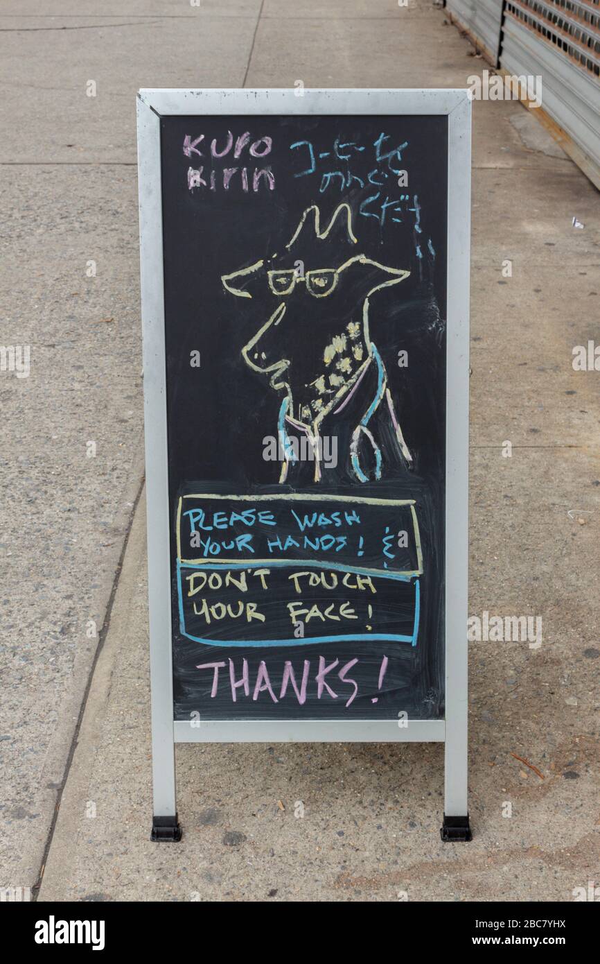 the Kuro Kirin cafe placed a colorful chalkboard sign on its sidewalk with a doodle telling people to wash their hands and not touch their faces Stock Photo