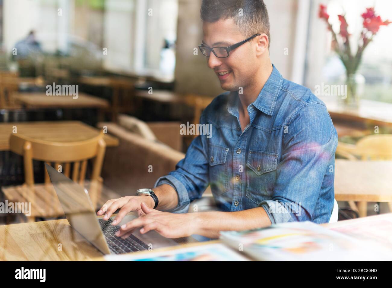 Young man using laptop at cafe Stock Photo