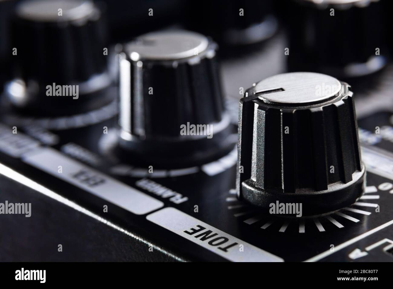 selective focus on the tone knob of an amplifier for electric musical