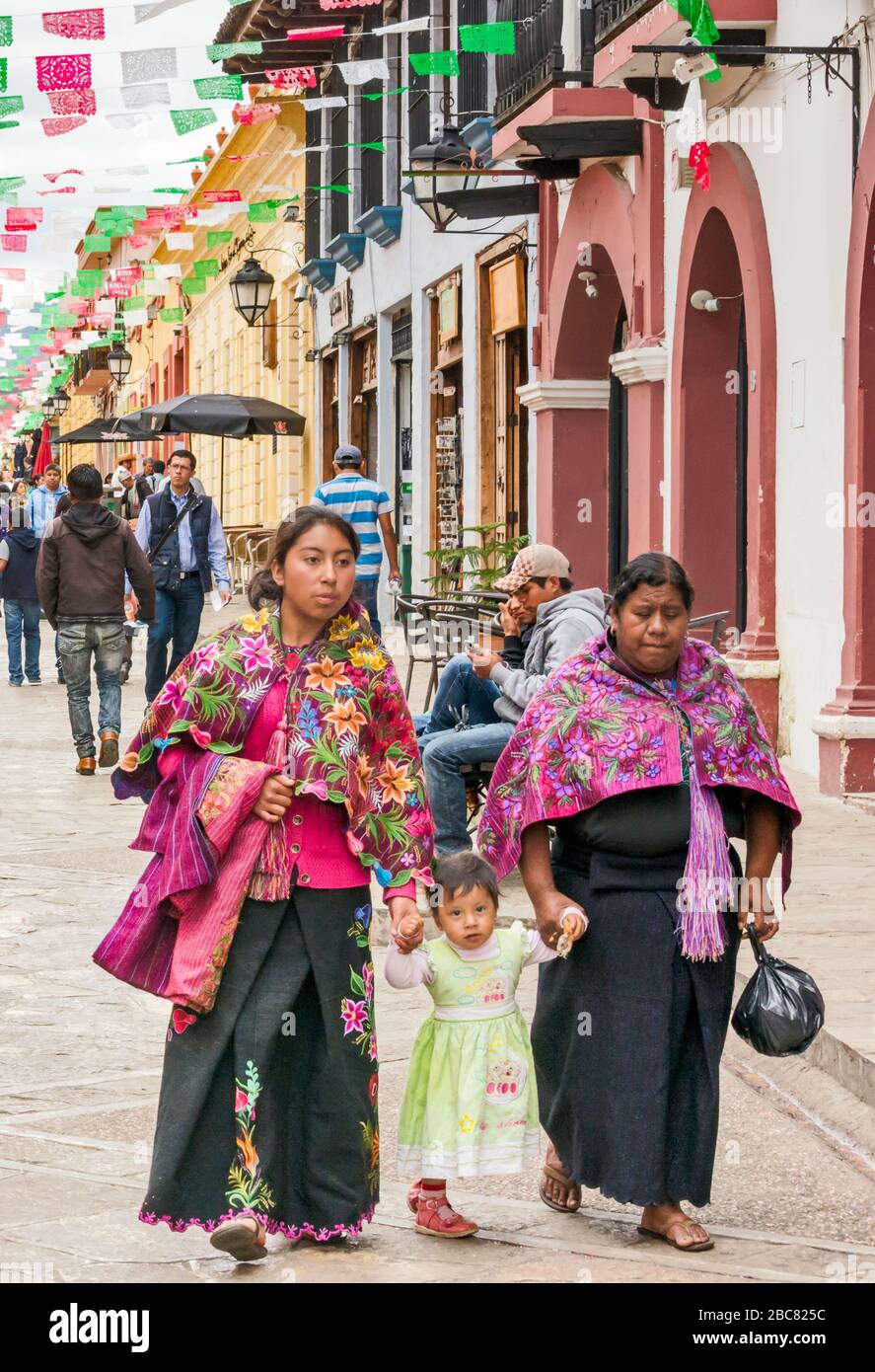 Two Maya women and child, wearing traditional dress, at Calle Real de Guadalupe, pedestrian street in San Cristobal de las Casas, Chiapas, Mexico Stock Photo