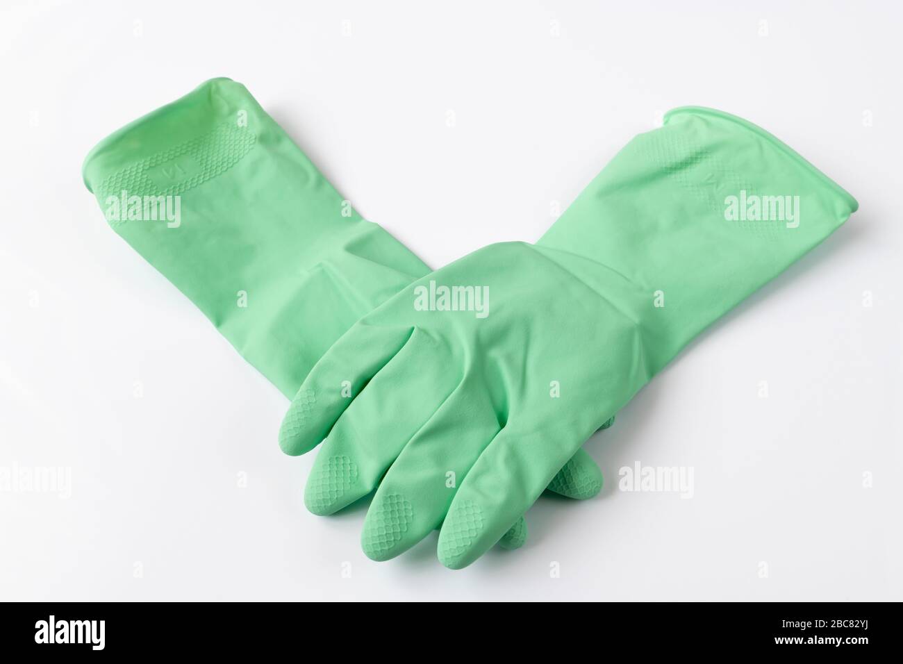 Green latex dishwashing gloves on a white background Stock Photo Alamy