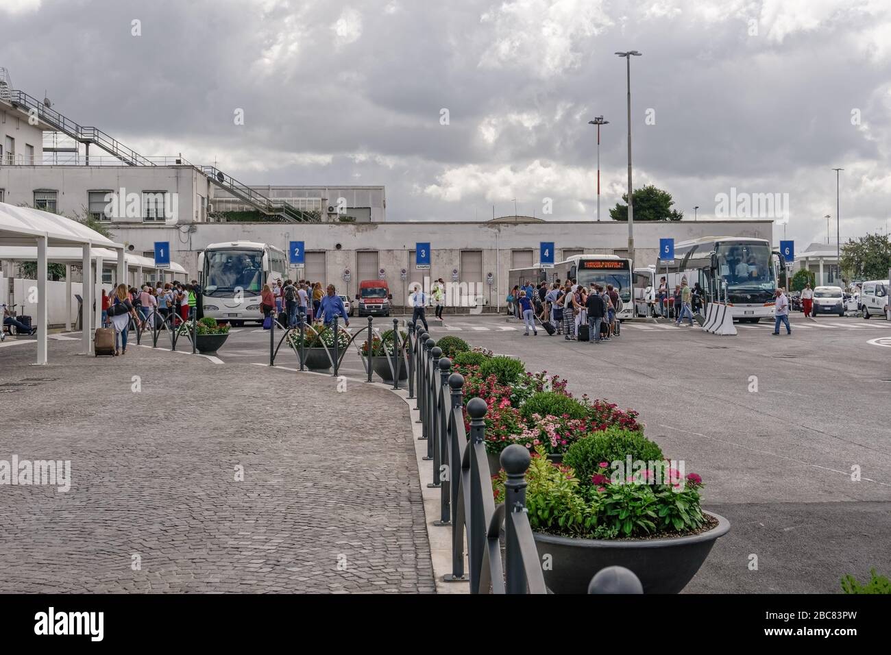 Rome, Italy Ciampino airport terminal bus stop with crowd. Aeroporto G. B. Pastine with tourists with luggage boarding coaches to the Italian capital. Stock Photo