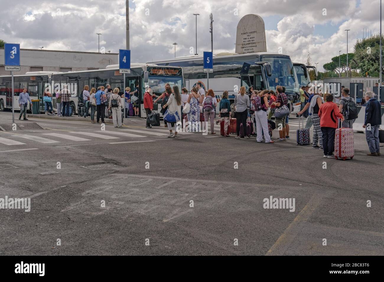 Rome, Italy Ciampino airport terminal bus stop with crowd. Aeroporto G. B. Pastine with tourists with luggage boarding coaches to the Italian capital. Stock Photo