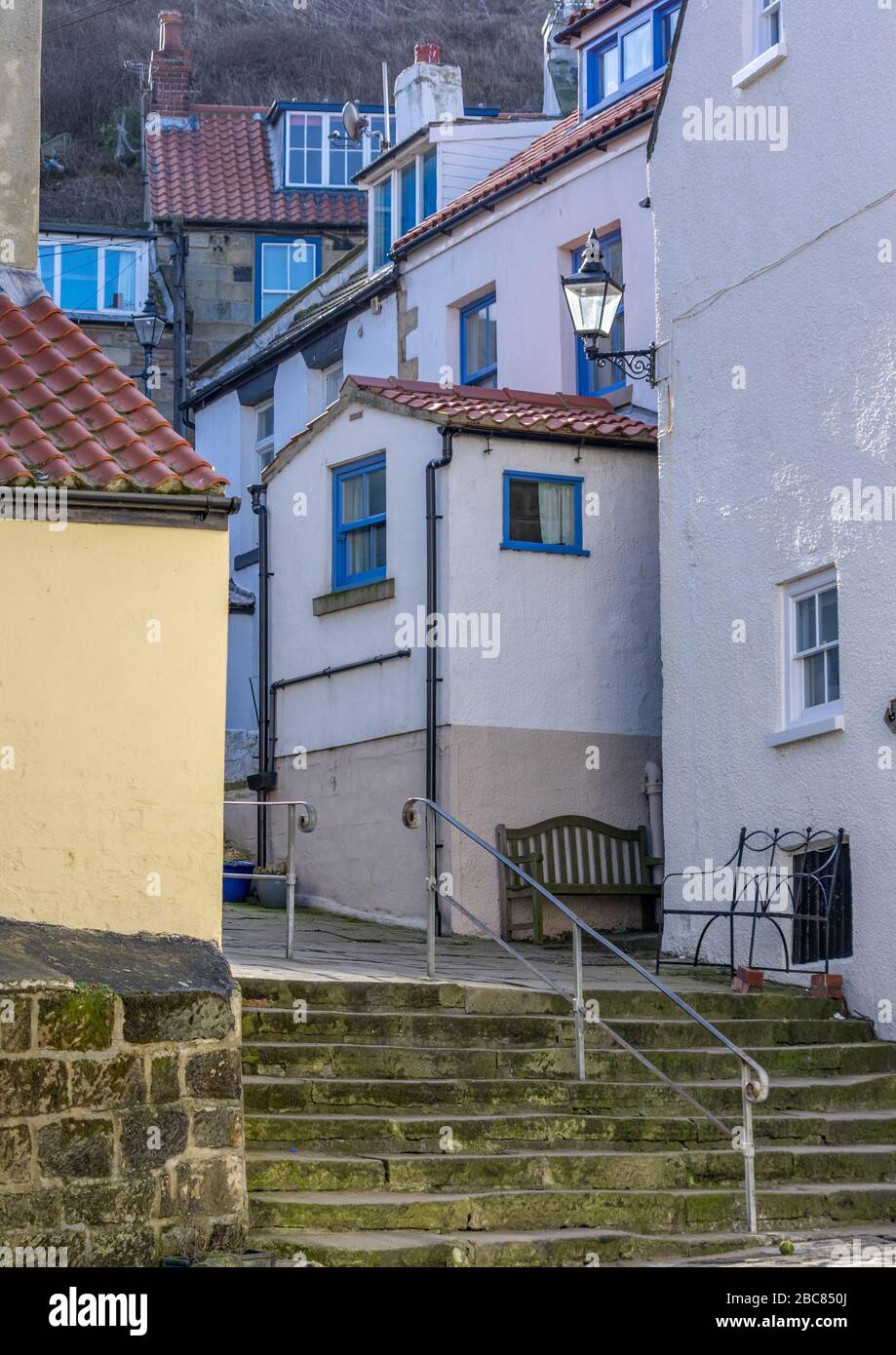 Houses lining a narrow street with steps leading to them in Staithes