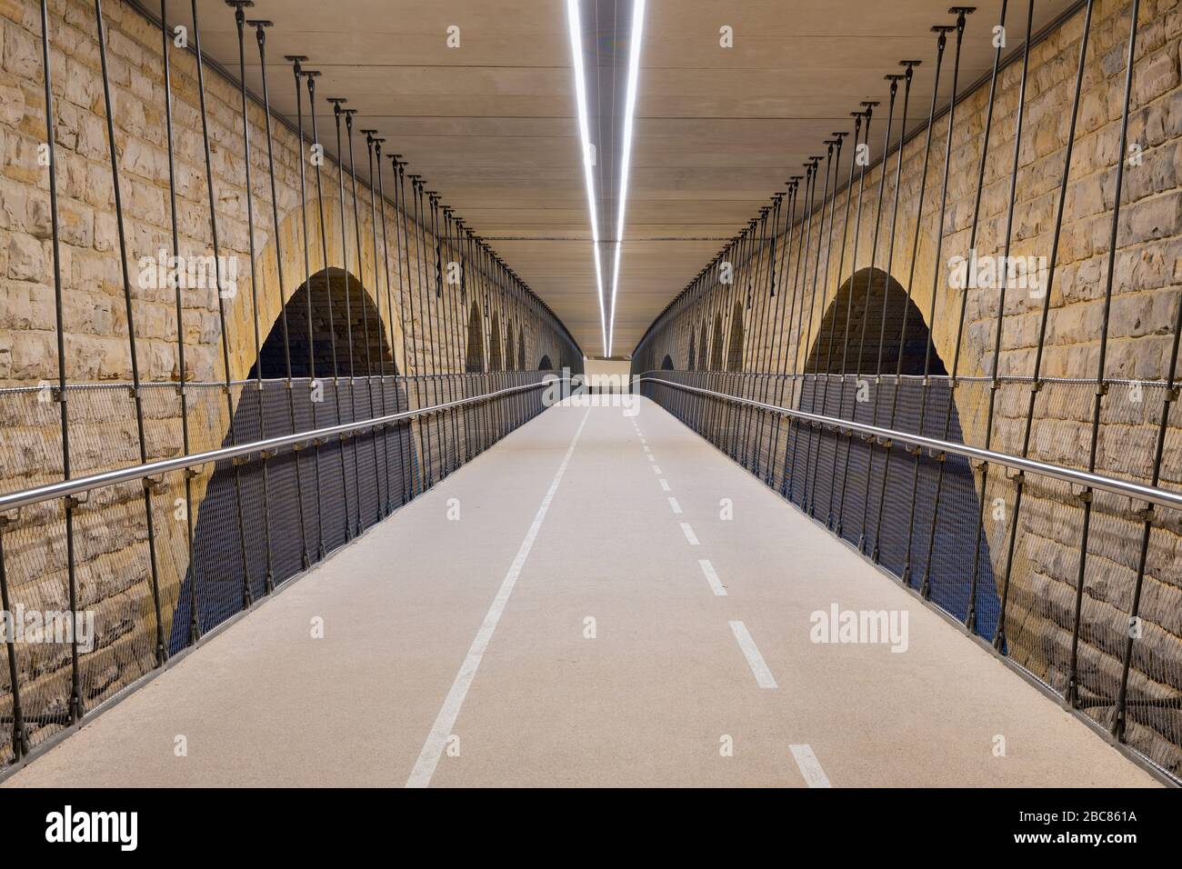 Illuminated cycle track below Pont Adolphe bridge Luxembourg city Stock Photo