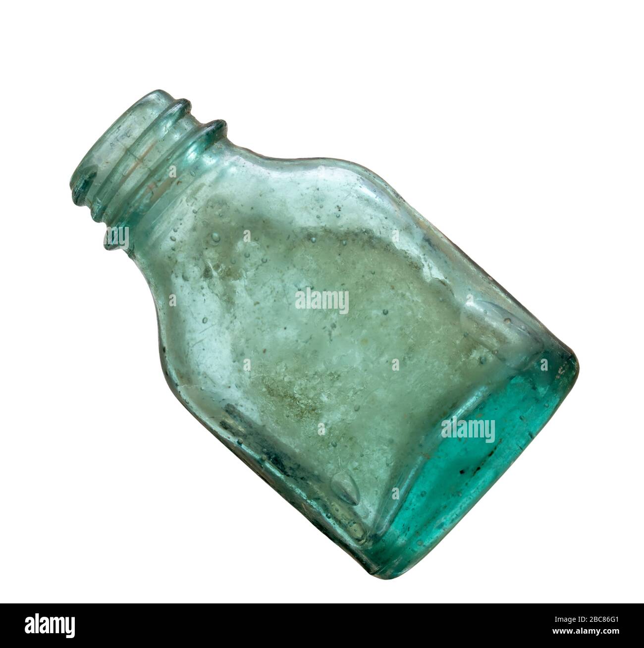 Very old green glass medicine bottle isolated on white. Looks hand blown. Stock Photo