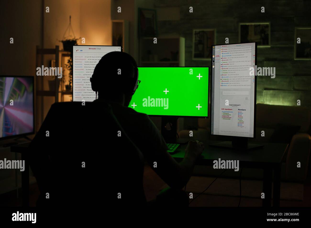 Back view of professional gamer playing on computer with green screen