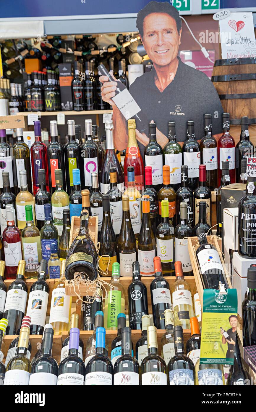 Bottles of wine on sale at stall in indoor market with Cliff Richard cutout, Loule, Algarve, Portugal Stock Photo