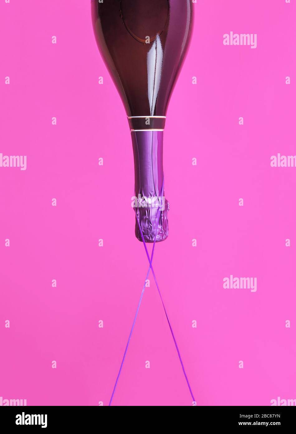 Champagne bottle upside down floats on bold color Stock Photo Alamy