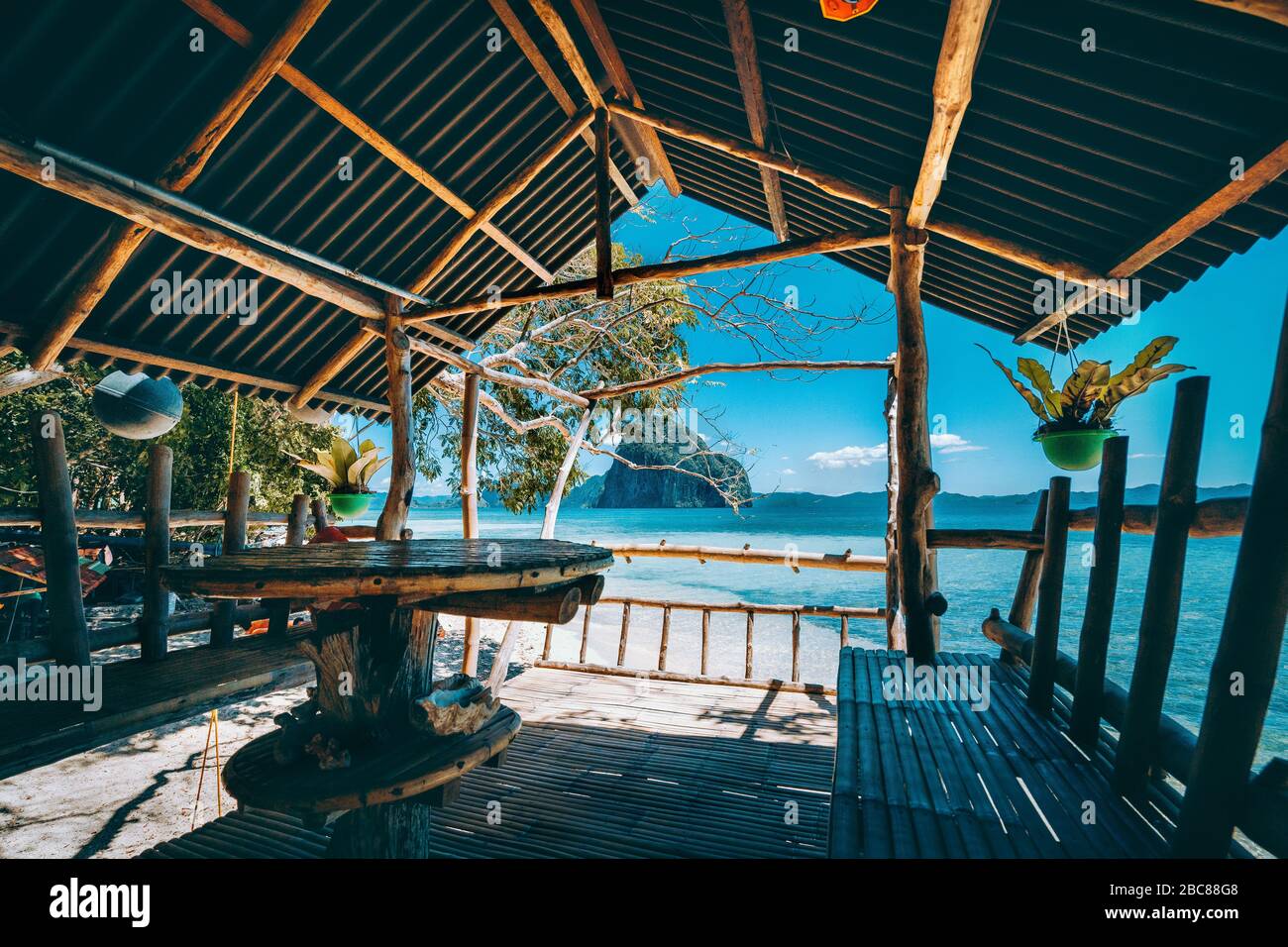Tropical getaway remote panorama of impressive Pinagbuyutan island from the native wood and bamboo terrace, beauty of Philippines island. Stock Photo