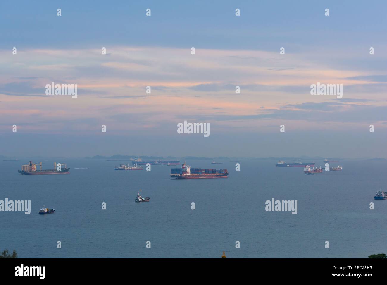 Cargo ships, oil tankers and bulk carriers anchored offshore along the