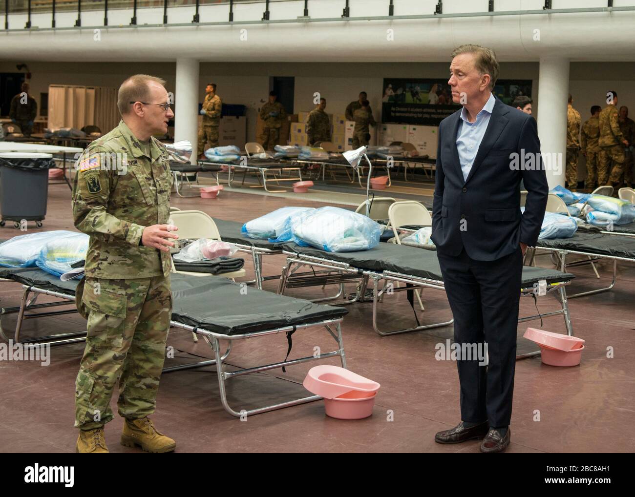 Maj. Gen. Francis Evon, The Adjutant General of the Connecticut National Guard, left, speaks with Connecticut Gov. Ned Lamont inside the Federal Medical Station in response to the COVID-19 pandemic at Moore Field House at Southern Connecticut State University April 1, 2020 in New Haven, Connecticut. Stock Photo