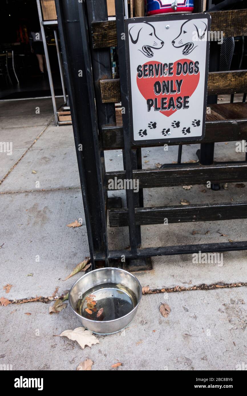 Service dogs only sign and water bowl for dogs outside a restaurant in the Boulder Mall, Boulder, Colorado, US Stock Photo