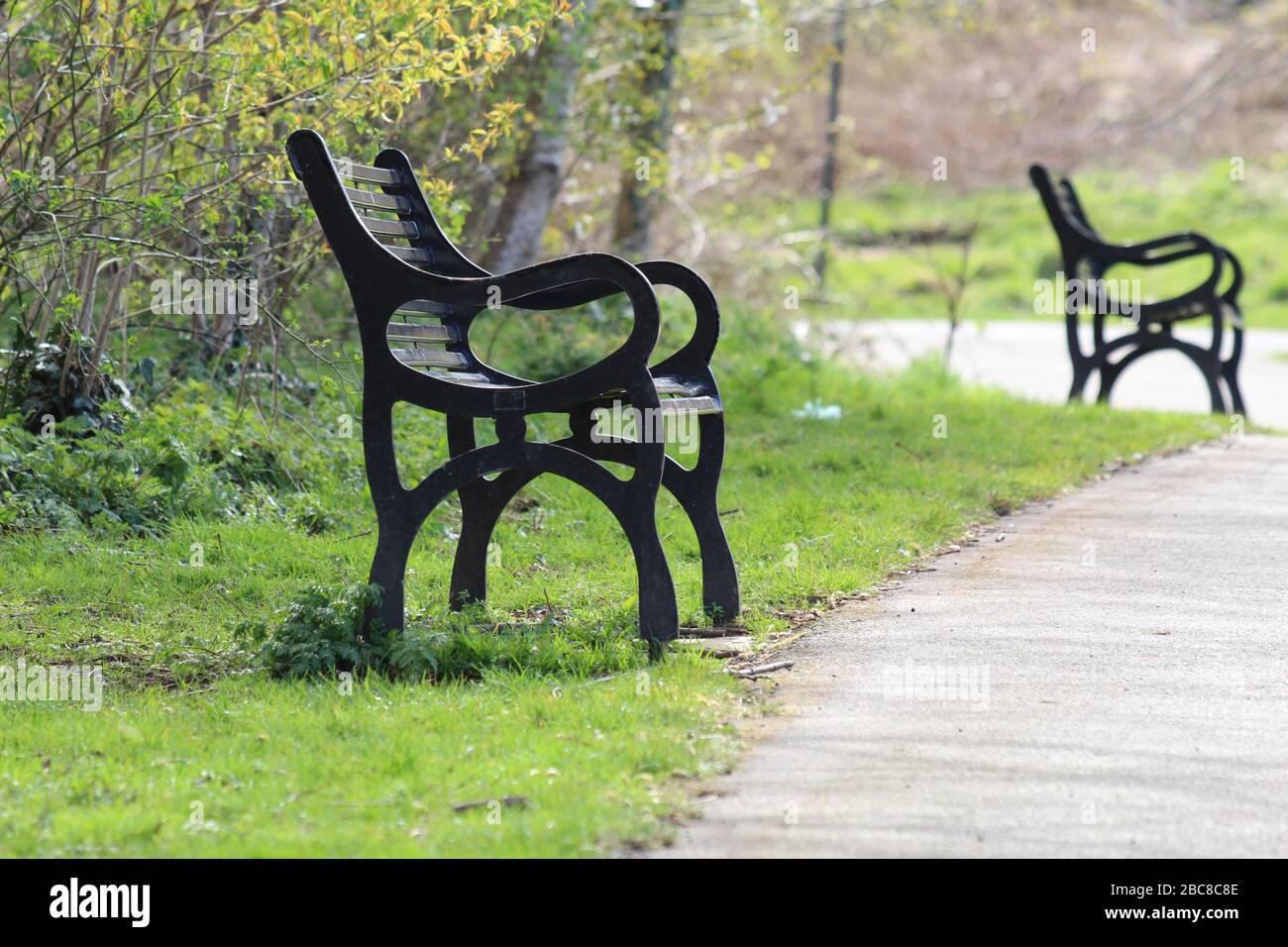 Vacant benches in an empty park during uk coronavirus lockdown Stock Photo