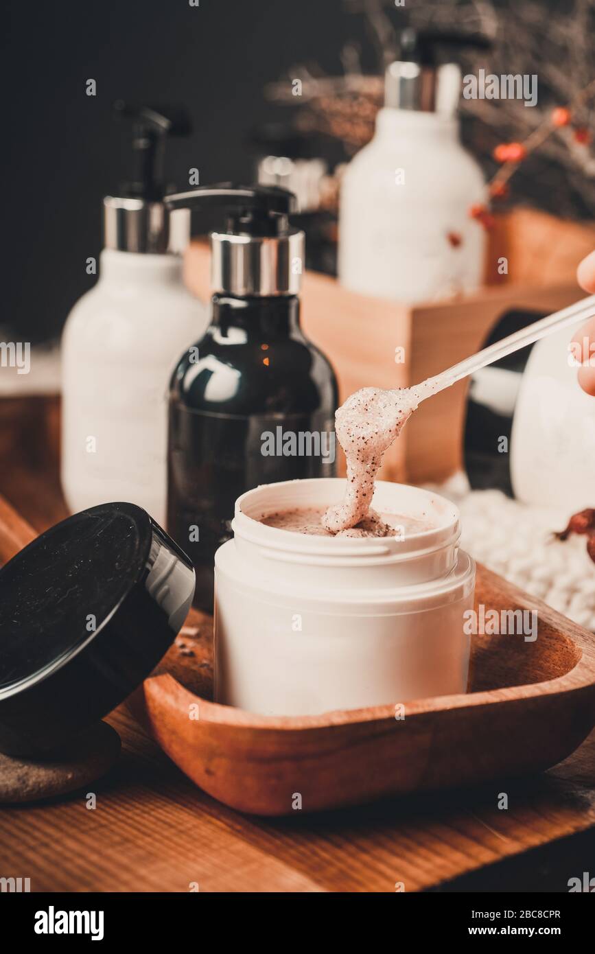Natural Spa, Scrub, peeling with sea salt and sugar Still life. Organic spa cosmetic products and natural skincare concept on dark wooden background Stock Photo