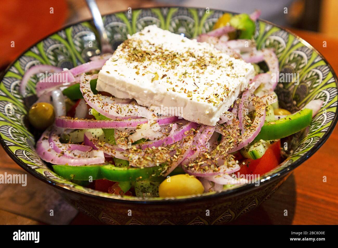 Salad topped by feta cheese and herbs served at Lindos on Rhodes, Greece. The dish features olives and onions. Stock Photo