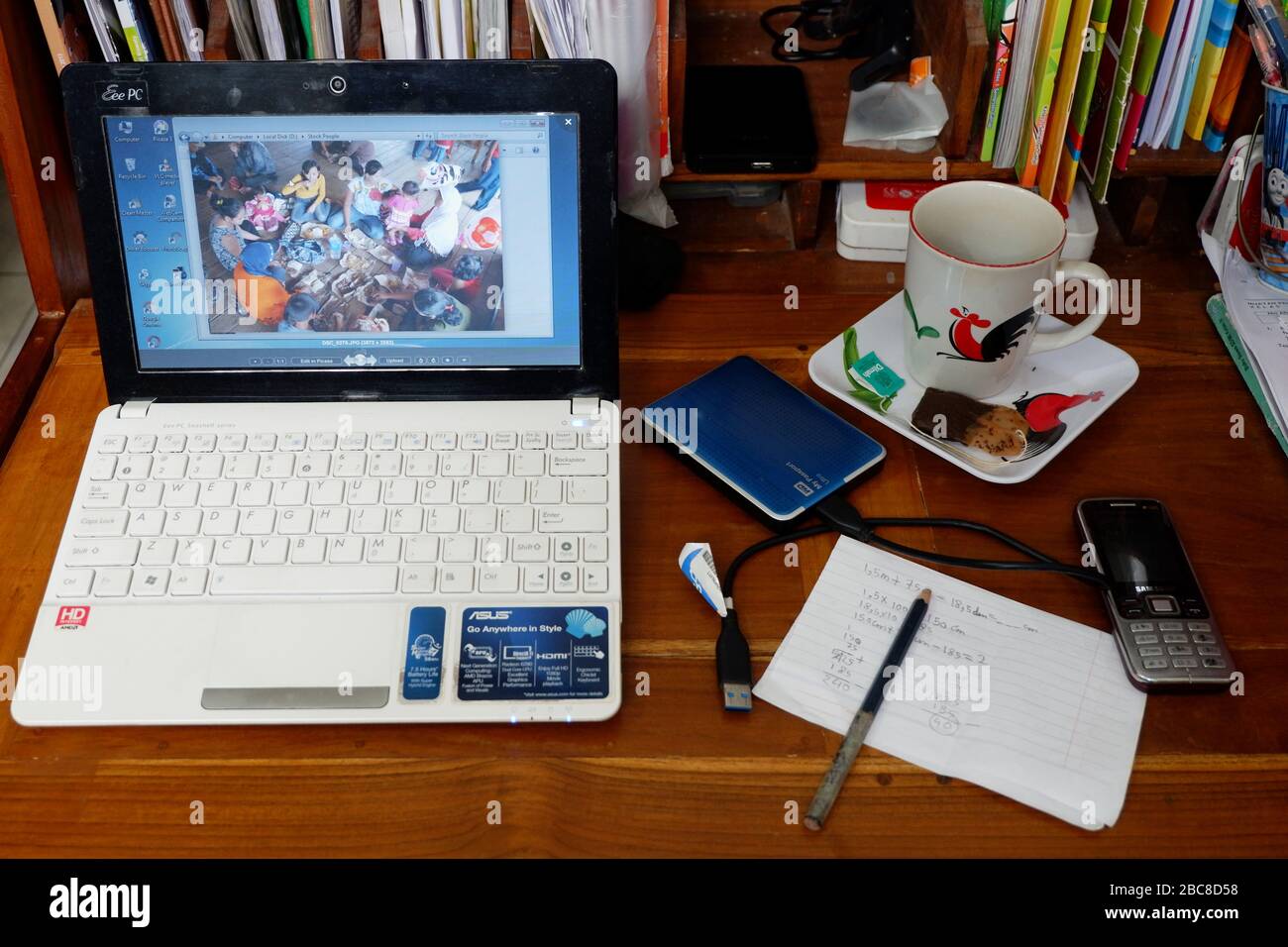 A laptop, an external harddisk, a mug of coffee, a cellphone, a note and a pen. Ready to work remotely at home. Stock Photo