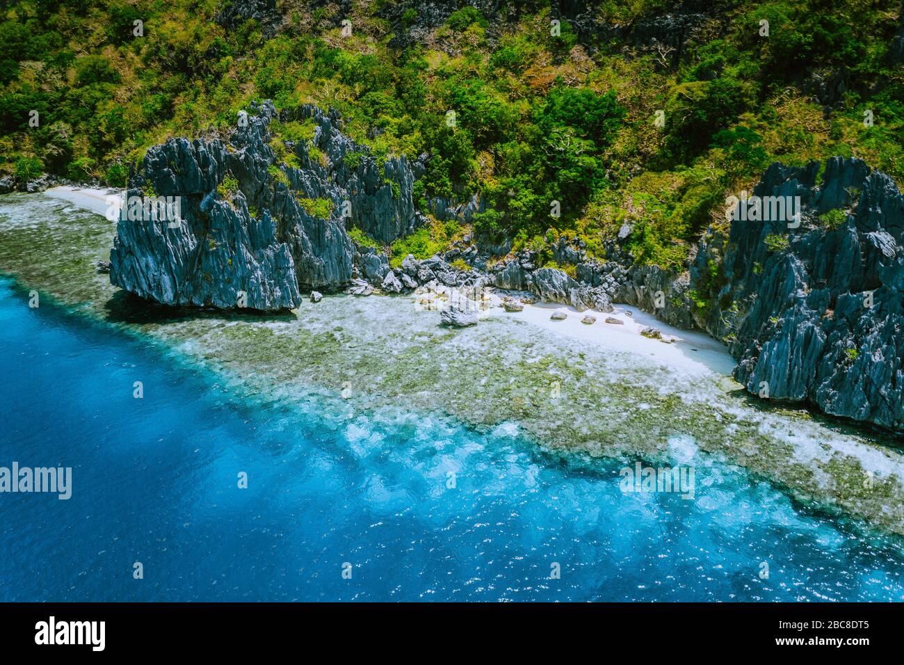 Aerial view of beautiful tropical limestone rocks, blue ocean and coral reef edge at El Nido, Palawan, Philippines. Stock Photo