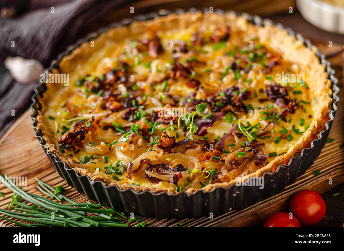 Delicious rustic quiche with roasted onion and crispy bacon Stock Photo