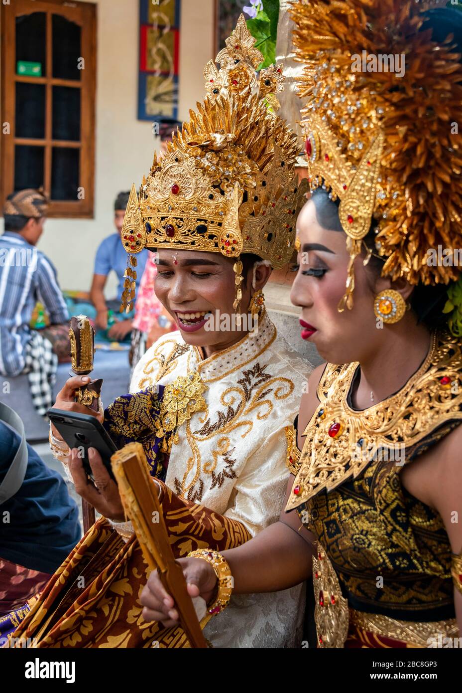 Vertical portrait of a bride and groom Facetiming at a Balinese wedding, Indonesia. Stock Photo