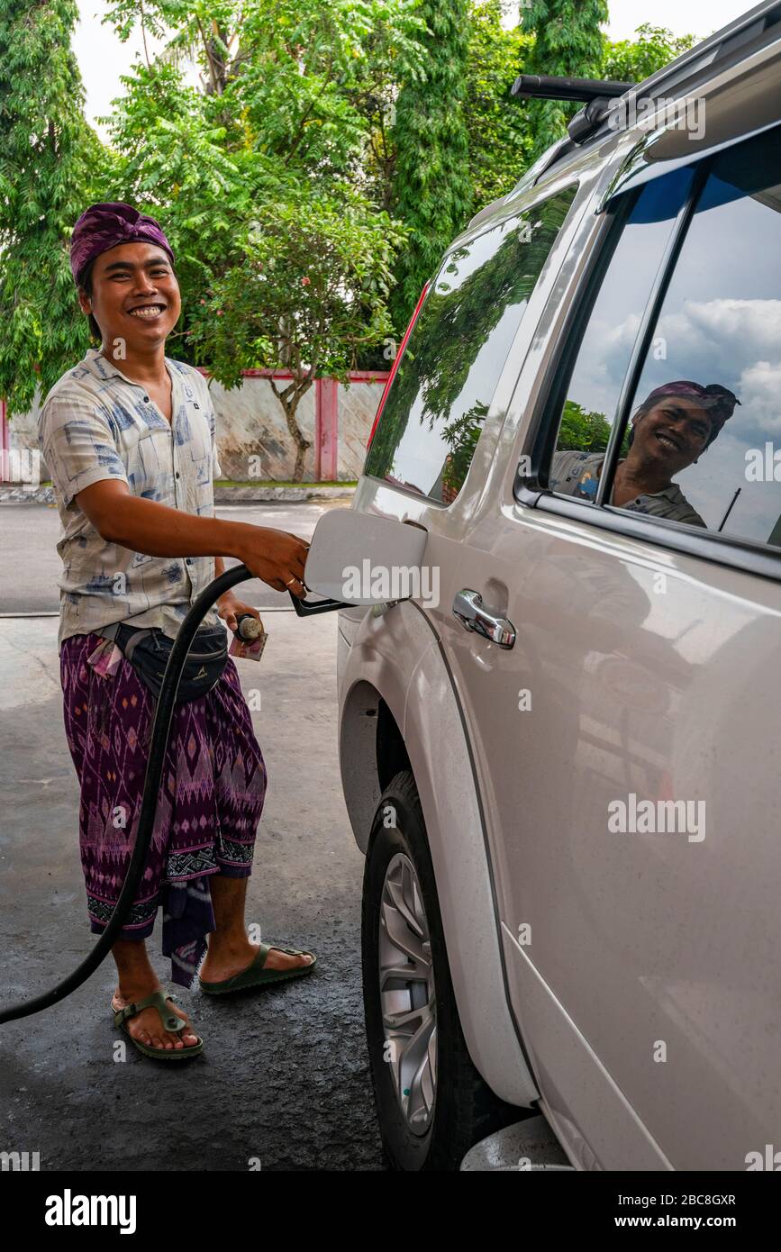 Vertical view of a man refuelling his car in Bali, Indonesia. Stock Photo