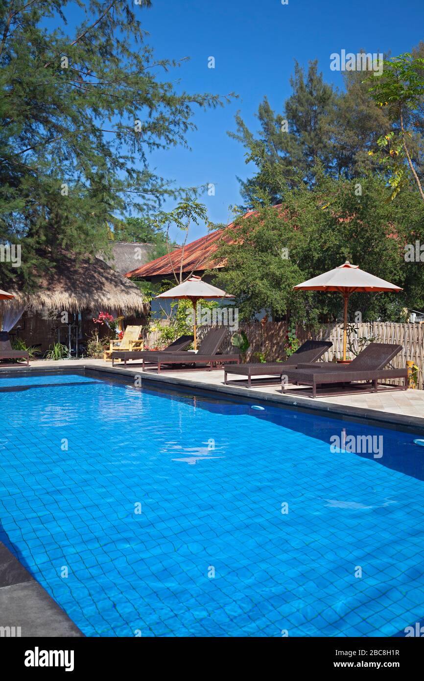 Asia, Indonesia, West Nusa Tenggara, Gili Air, Pool and Loungers at Bambu Cottages (Resort) Stock Photo