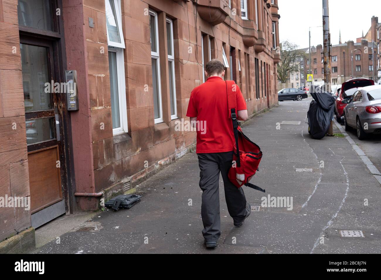 Glasgow, Scotland, UK. 3 April, 2020. Images from the south side of Glasgow at the end of the second week of Coronavirus lockdown. Pictured; Royal Mail postman making deliveries to tenement in Govanhill . Iain Masterton/Alamy Live News Stock Photo