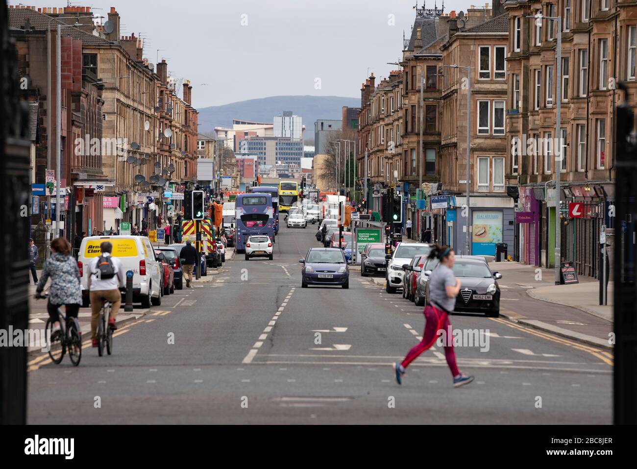 Glasgow, Scotland, UK. 3 April, 2020. Images from the south side of Glasgow at the end of the second week of Coronavirus lockdown.  Jogger runs past a very quiet Victoria Road in Govanhill.  Iain Masterton/Alamy Live News Stock Photo