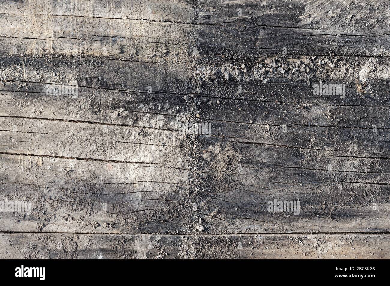 Charred and Weathered Construction Timber  Background with Mineral Adherences Stock Photo