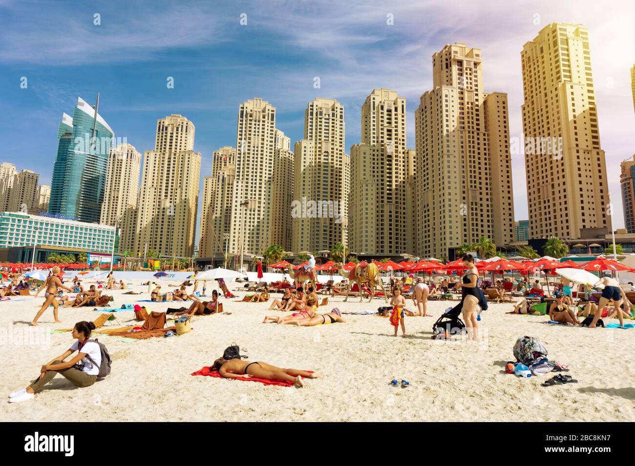 Dubai,UAE 10.31.2018 : crowded JBR Jumeirah beach with tourists enjoying the sun and the sea with skyscapers in the background . Stock Photo