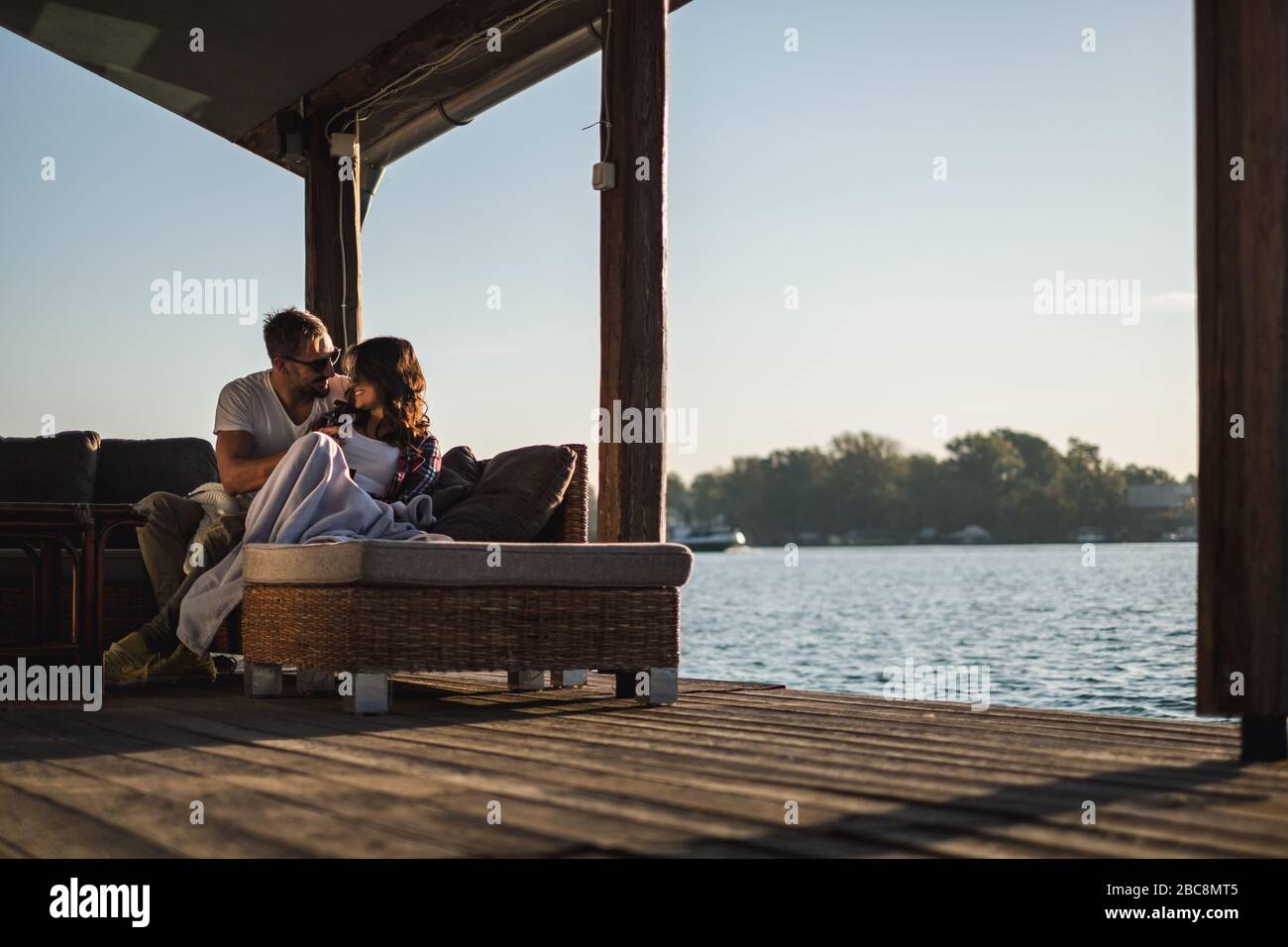 Smiling couple looking at each other by the riverr. Beautiful autumn day Stock Photo