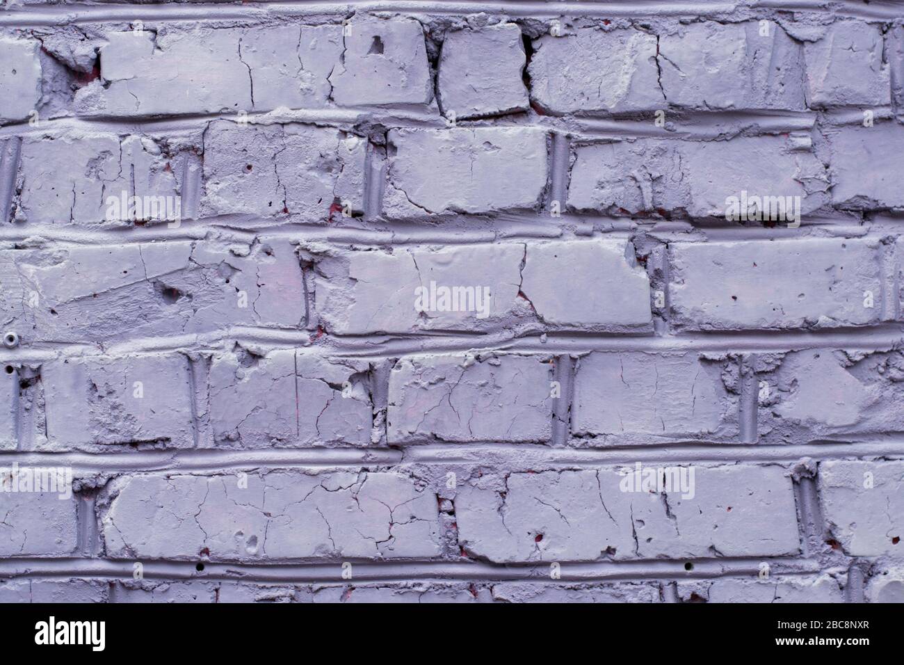 Brick wall painted in violet color, background Stock Photo