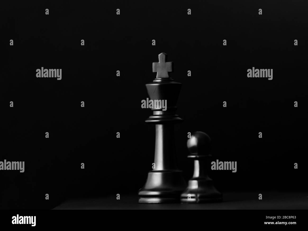 A conceptual still life shot of a King and a pawn Stock Photo