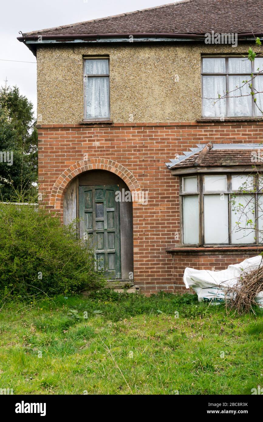 Old house with a mix of pebble dash and brickwork, woodwork in need of painting.. Stock Photo