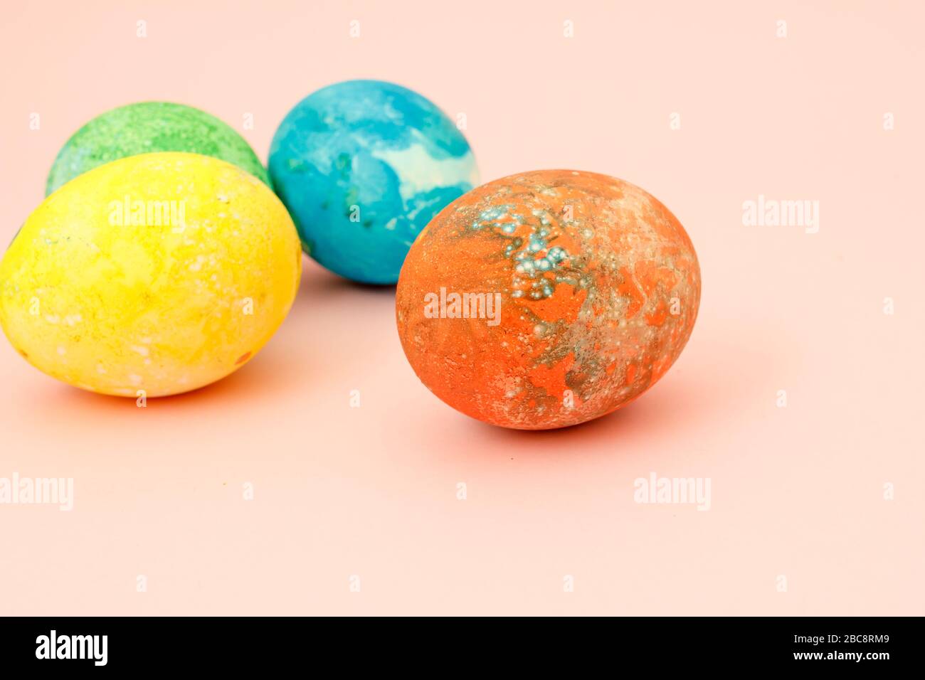 Four multi-colored Easter eggs top view, space for text. Concept happy easter day. Stock Photo