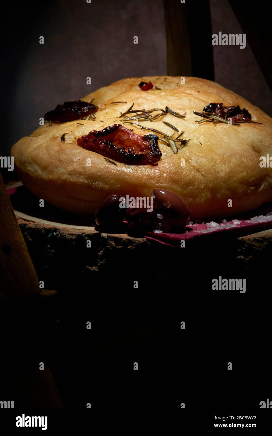 Display of homemade Italian style Focaccia loaf with rosemary, sun