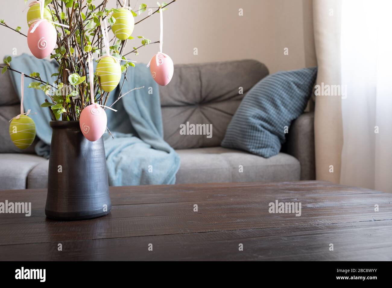 Spring home interior with Easter tree decorated colorful eggs. Quarantine. Self isolation. Stock Photo