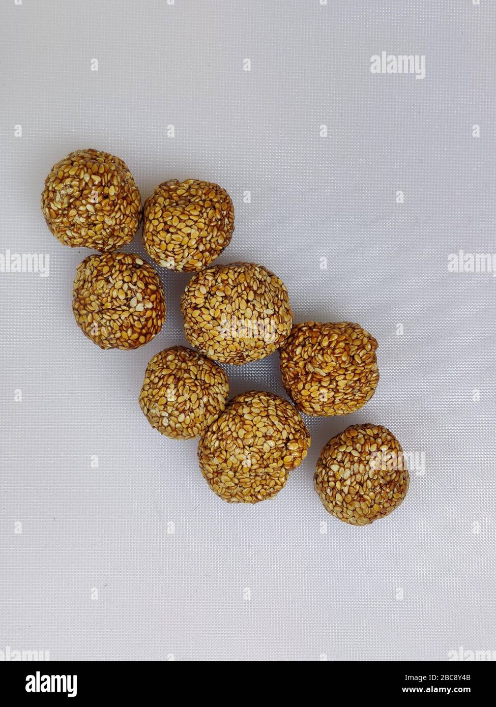 Til Gul OR Sweet Sesame Laddu for Indian festival Makar Sankranti over white background Stock Photo