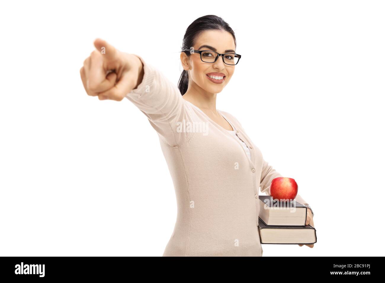 Young woman with glasses holding books and pointing isolated on white background Stock Photo