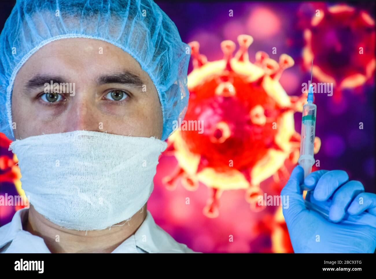 A man in a mask and protective gloves on the background of the image of a coronavirus. Doctor with a vaccine and a syringe. Stock Photo