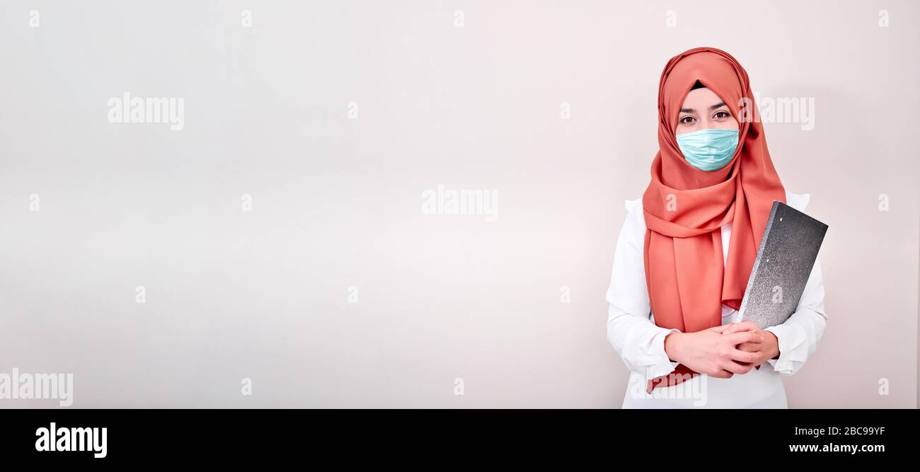 Muslim girl wearing surgical mask for protection. Hijab woman take a